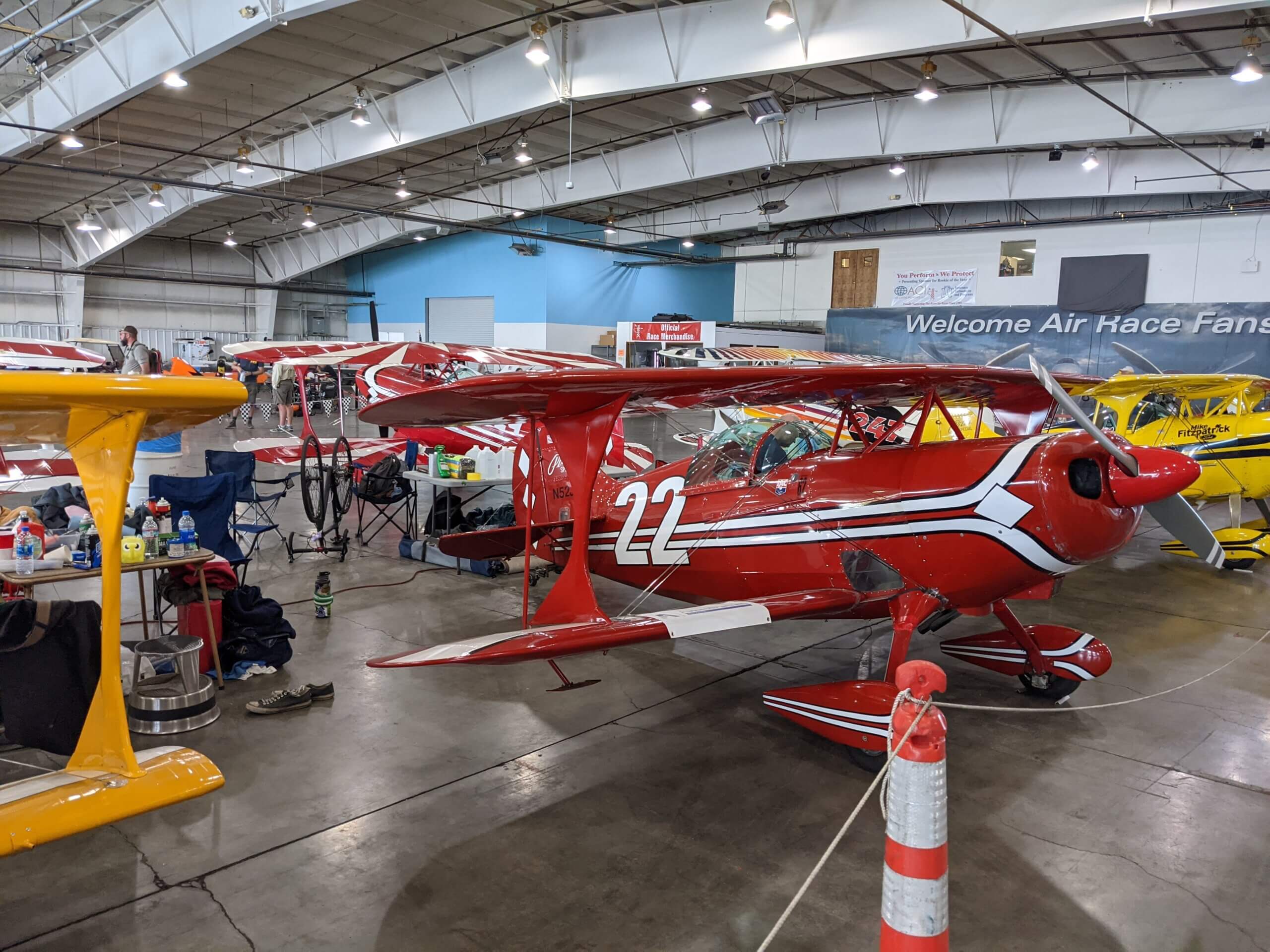 A row of Pitts Special biplanes in the hangar between races