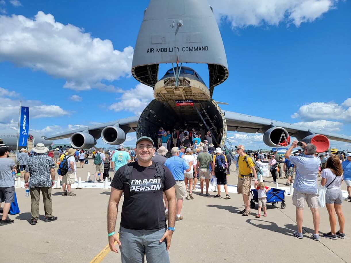 Microsoft Flight Simulator Senior Data Scientist Parsian posing in front of a C-5 Galaxy military transport plane