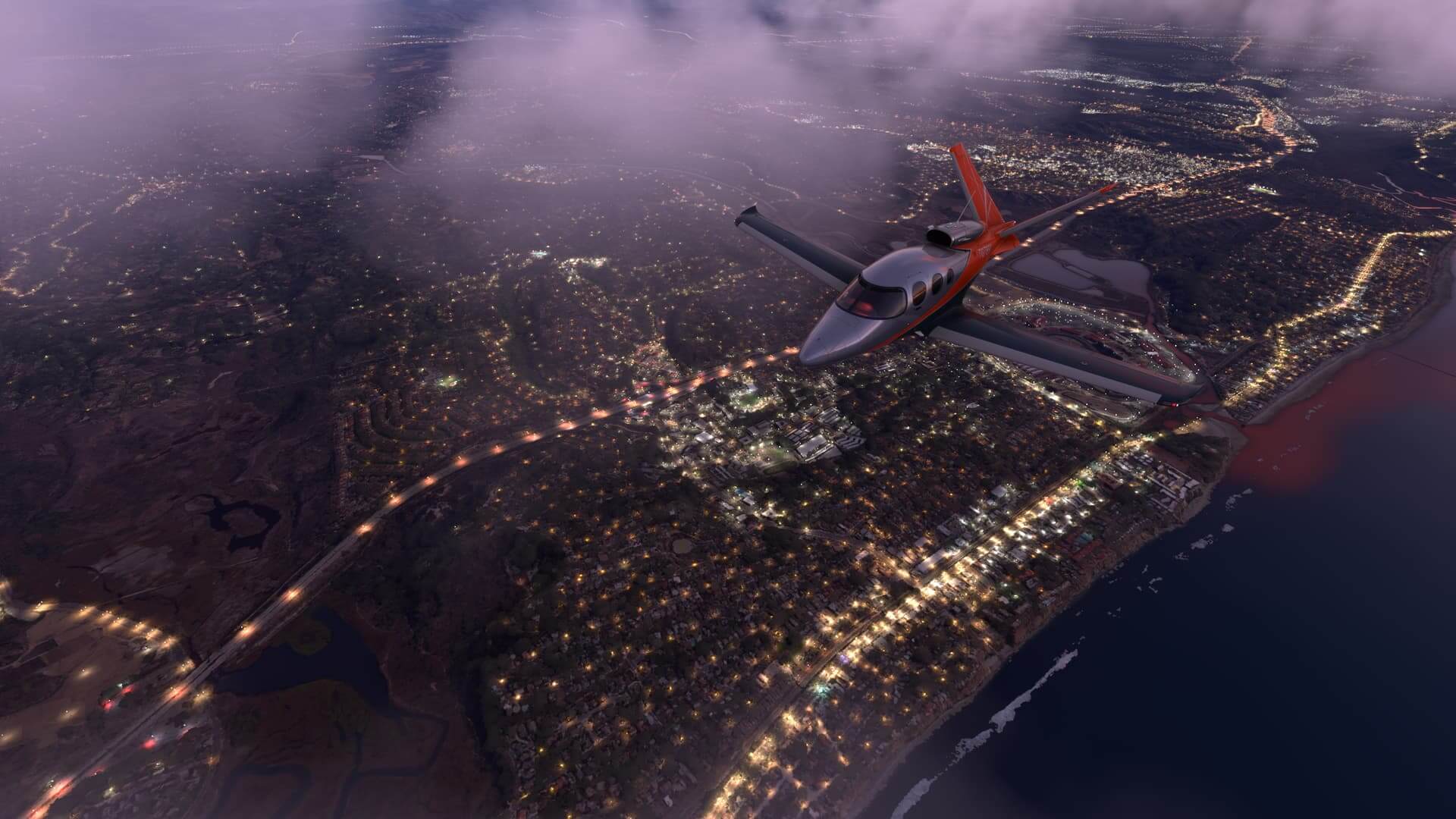 A plane flies over a city at dusk.