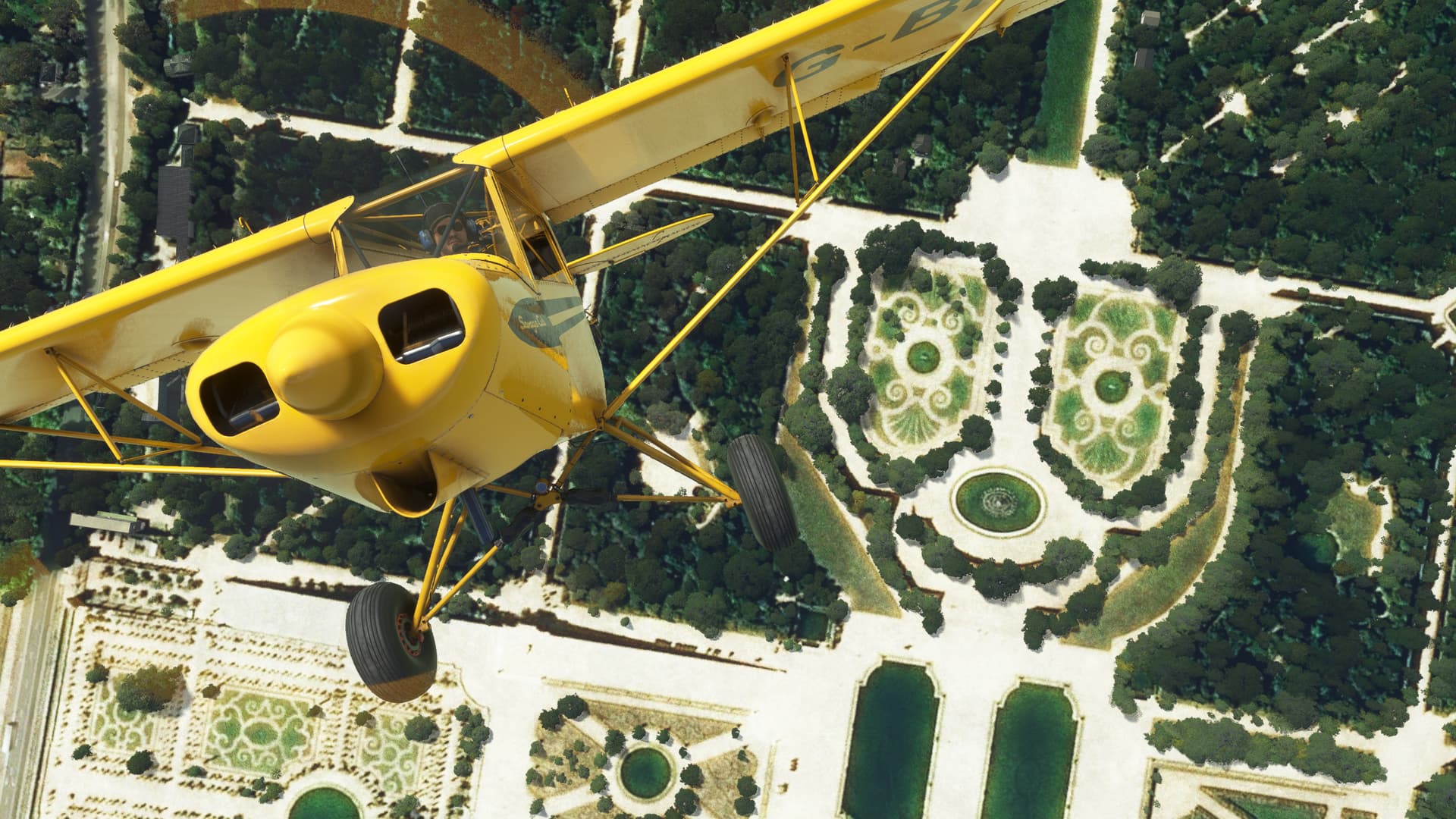 A head on view of a Savage Cub flying straight up toward the camera over the palace of Versailles. There are several gardens and fountains visible below.
