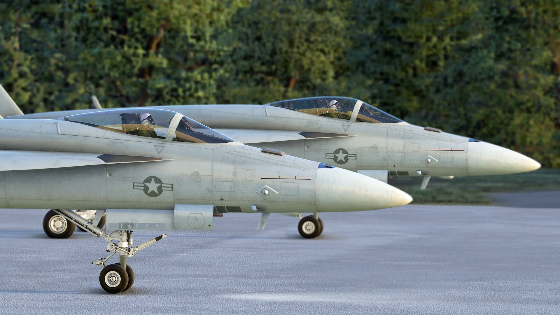 A side view of the cockpit and nose sections of two F/A-18 Super Hornets parked on the ground together. There are green trees visible in the background.