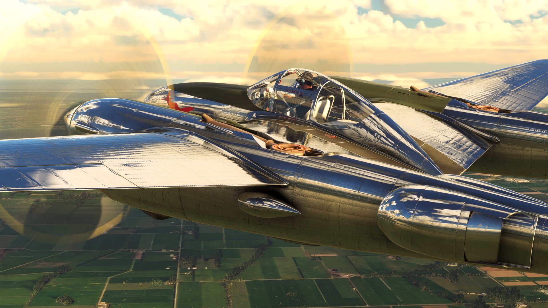 A P-38 Lightning with a reflective metallic finish flies over a green countryside.