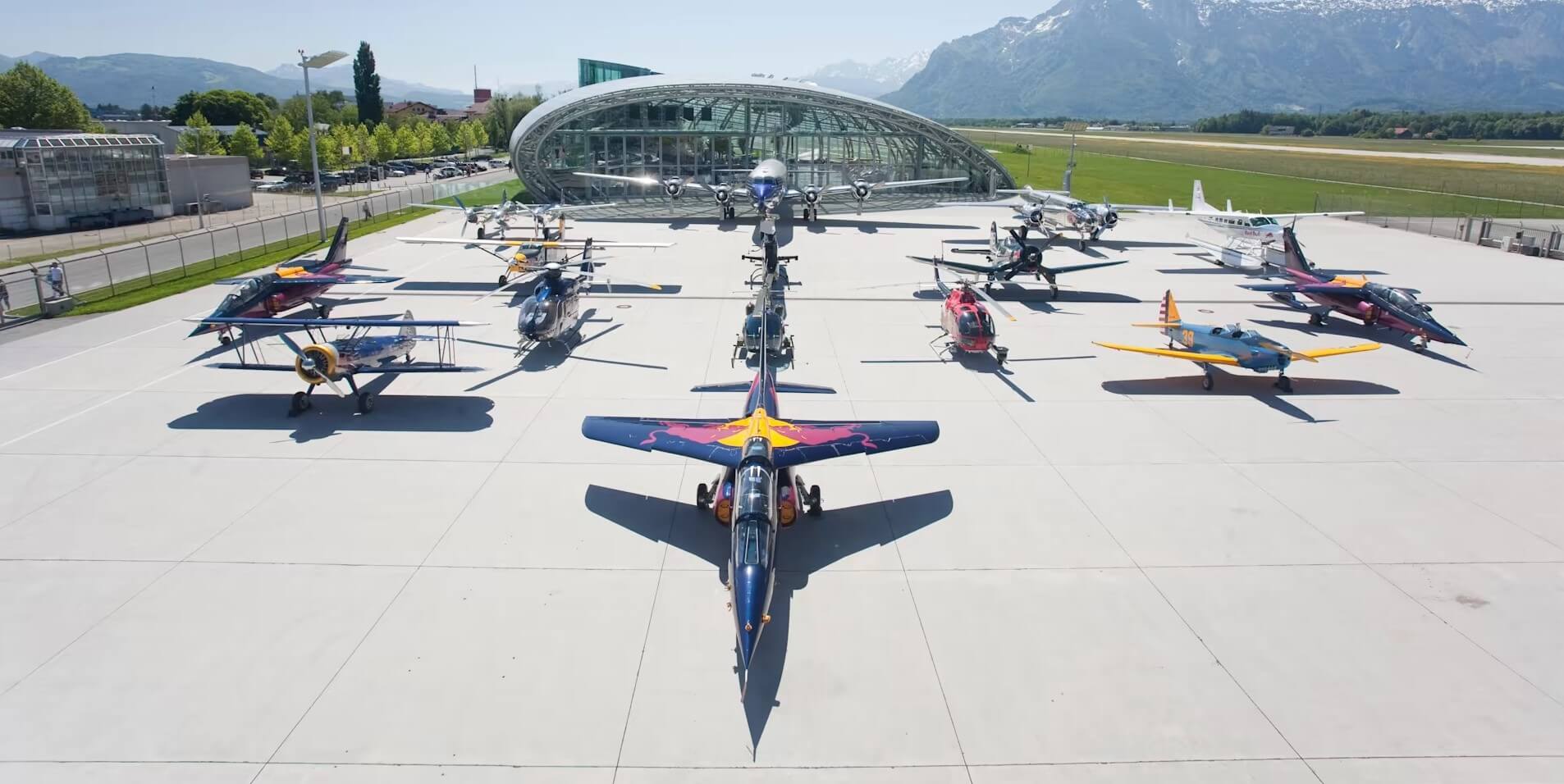 Multiple aircraft with Red Bull liveries parked on a ramp at an airport in Austria.