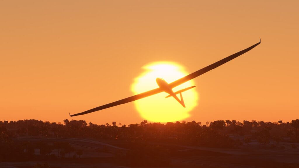 A glider is silhouetted against a bright yellow sun.