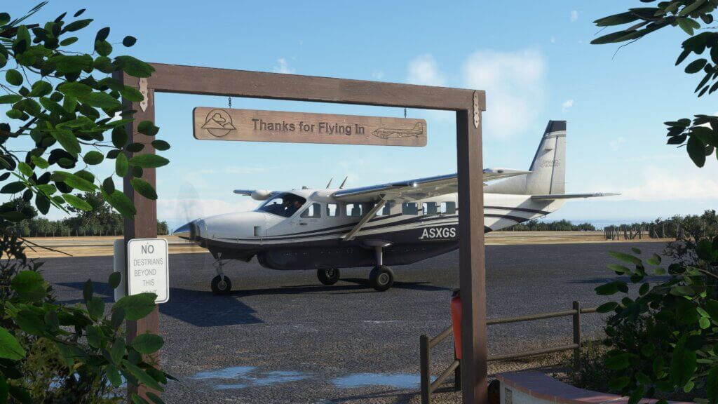 A Cessna Grand Caravan is parked next to a sign that says 