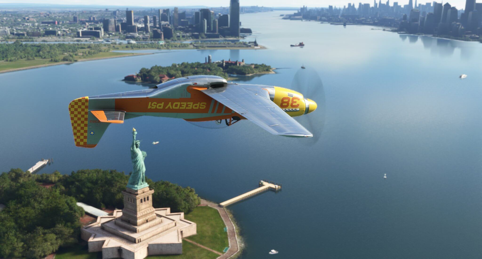 A P-51 yellow and silver Mustang passes inverted over the Statue of Liberty in New York City.