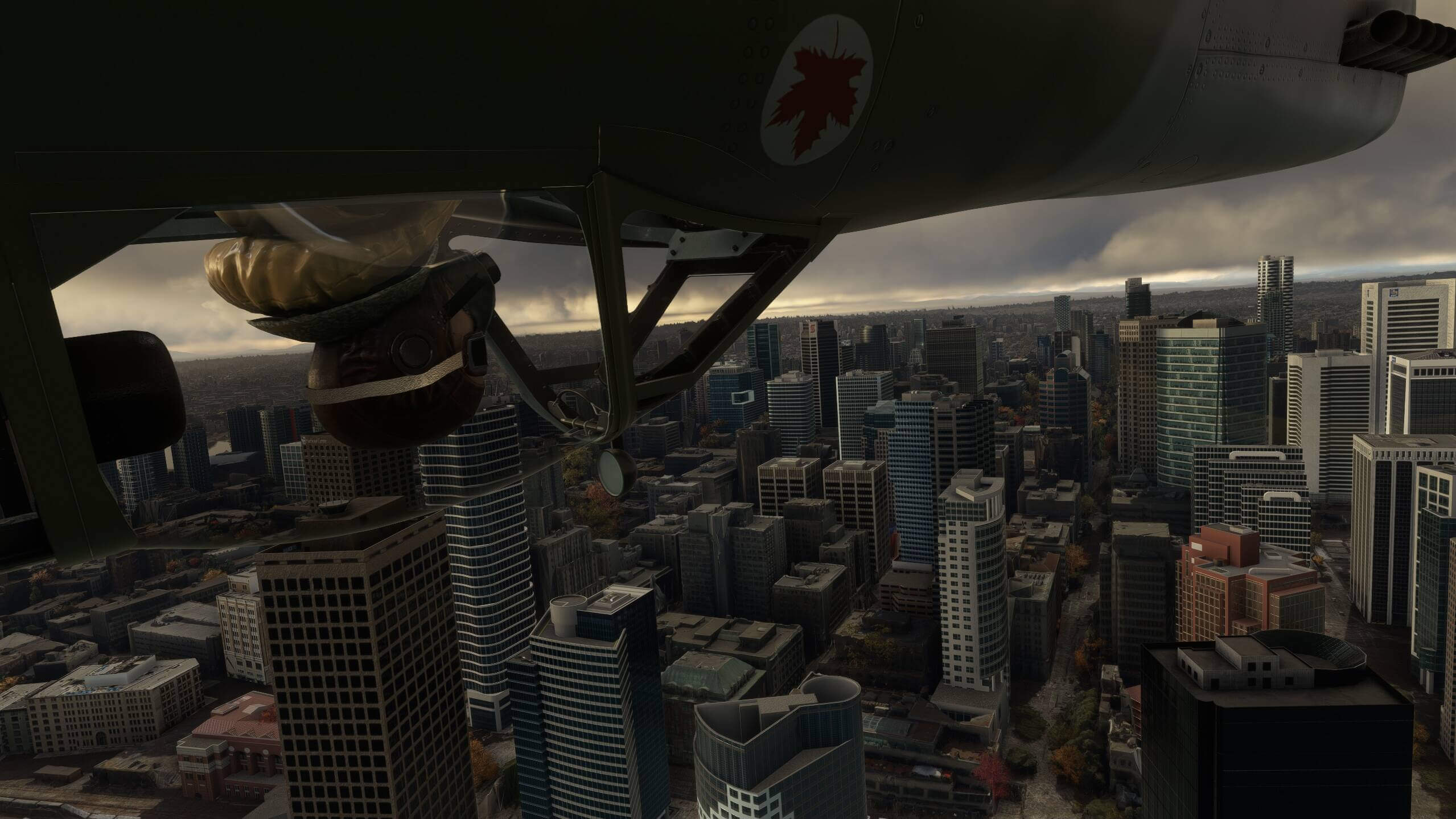 A Canadian warbird flies inverted over a city skyline with the pilot in view inside the canopy looking forward.