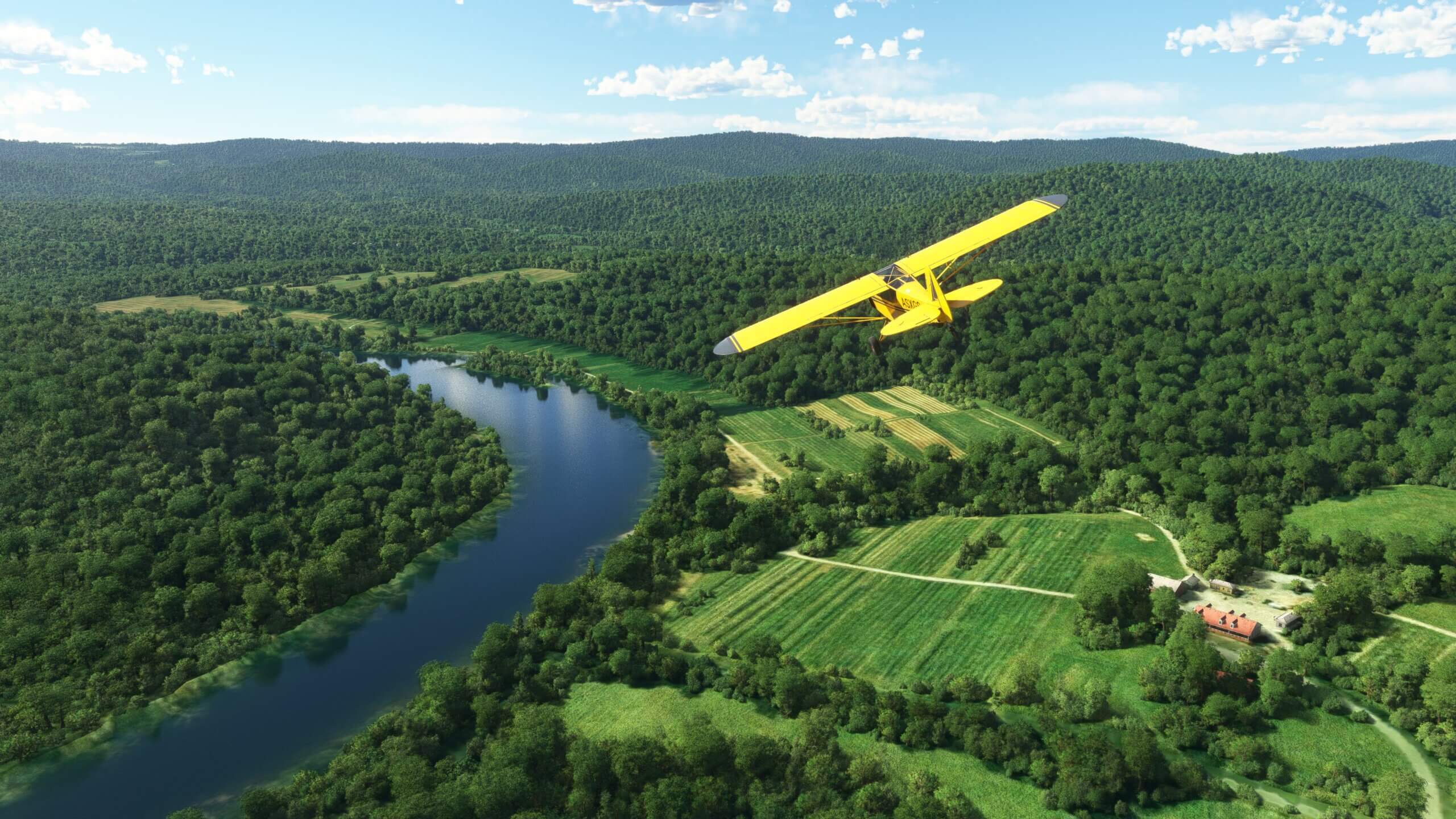 The Shock Ultra aircraft in yellow paint scheme follows a river below, which is surrounded by dense forestry and a country house below