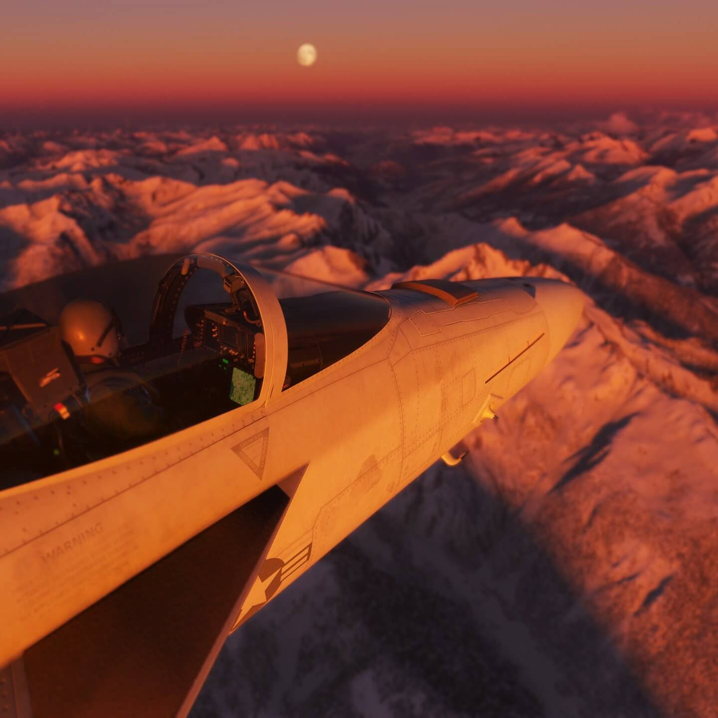 An F-18 Hornet cruises above snowy mountains