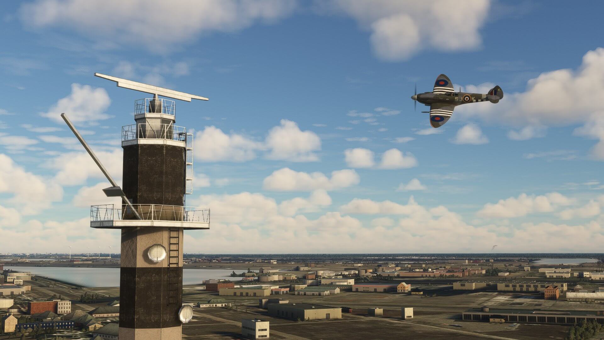 A Spitfire banks left passing over a radio tower