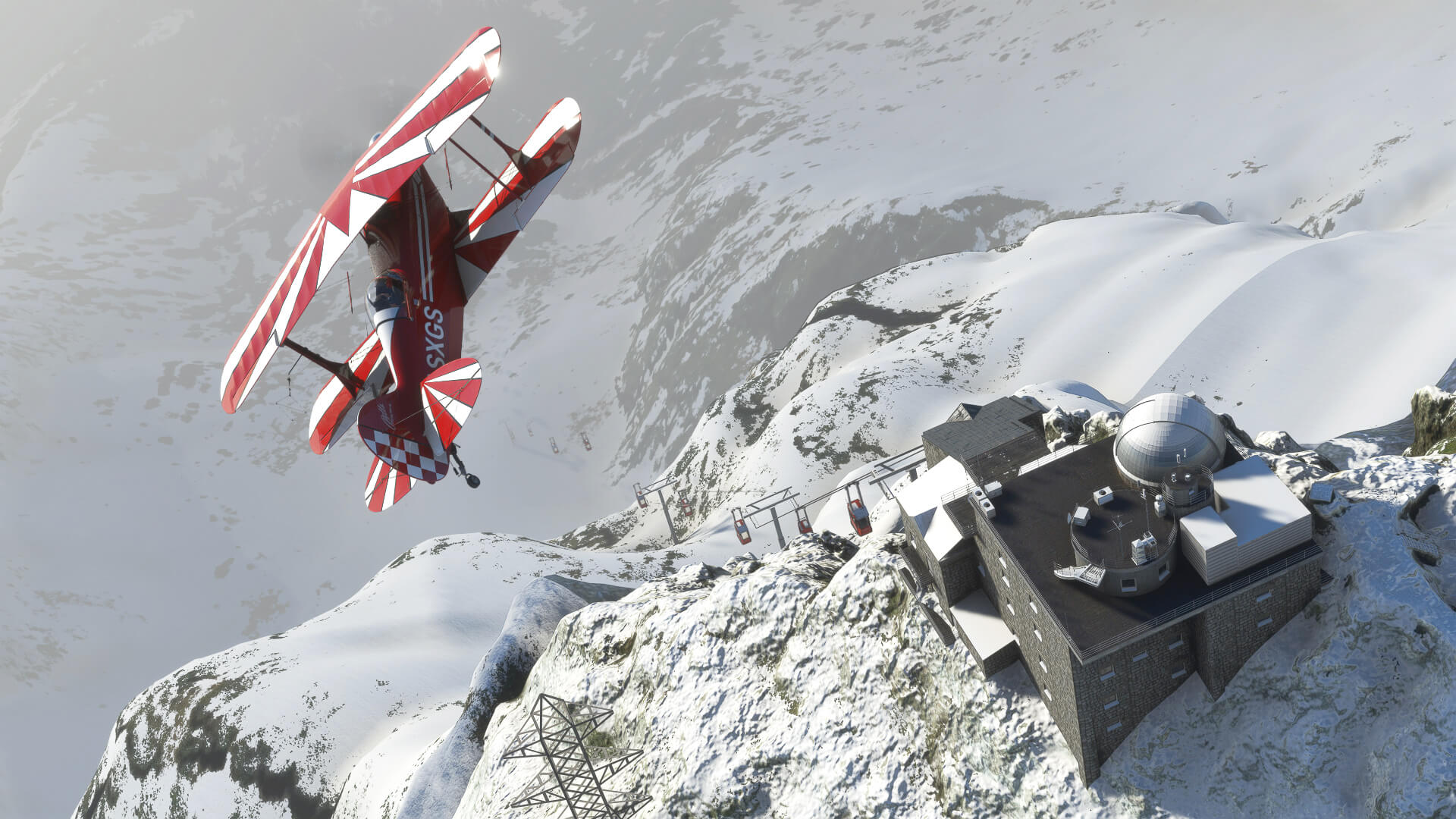 The Pitt bi-plane flies over a snow lift running down the side of a mountain.