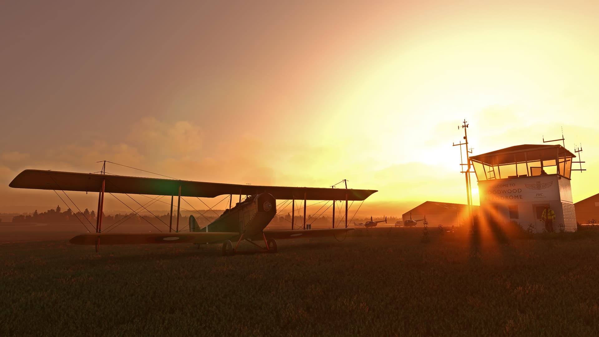 A bi-plane sat on the grass apron at Goodwood Aerodrome