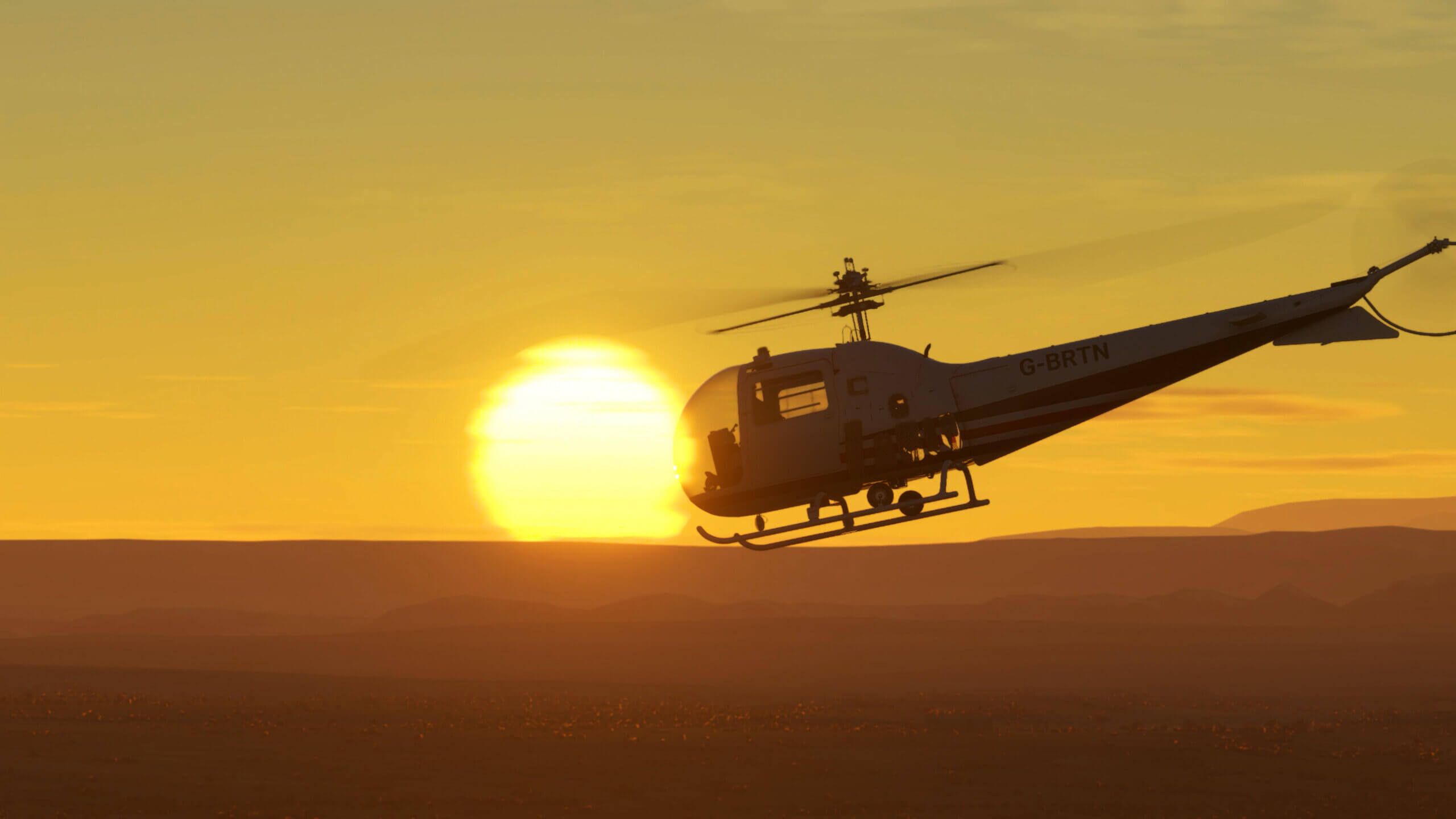 A Bell 47J Ranger flies next to a setting sun