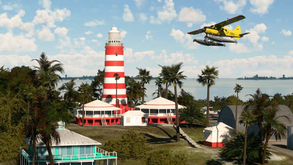 An airplane on floats flies over a red and white striped lighthouse in the Caribbean