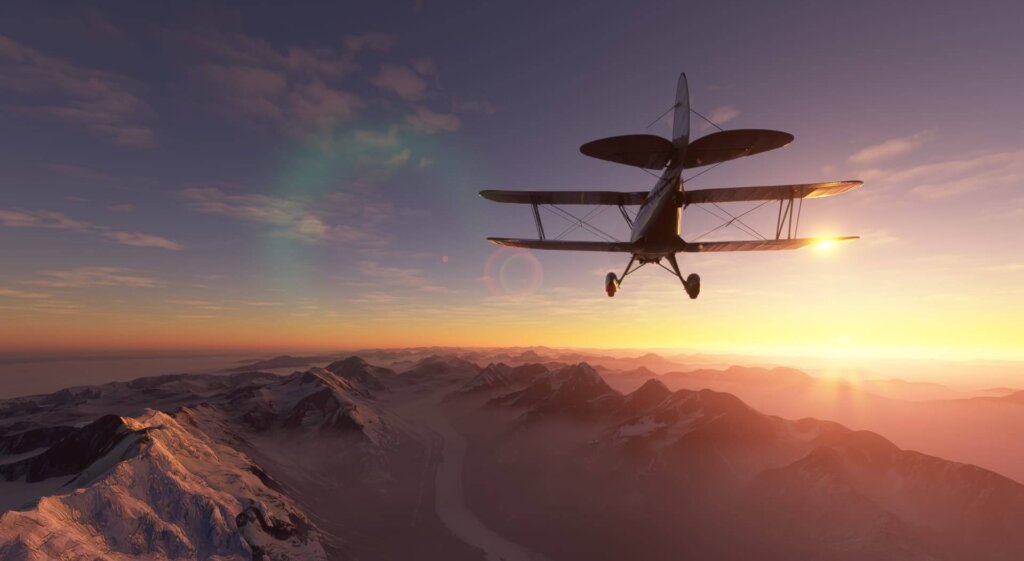 Bi-plane passes high over snowy mountain ranges