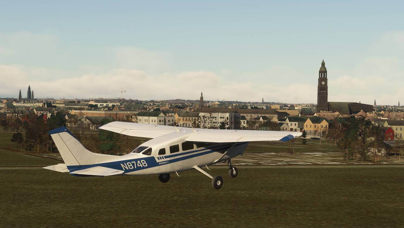 A high-wing Cessna flies low over fields near The Hague