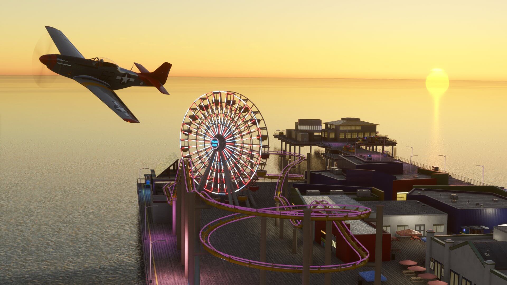 A P-51 Mustang flies over Venice Beach Pier in California with the sun setting on the horizon.