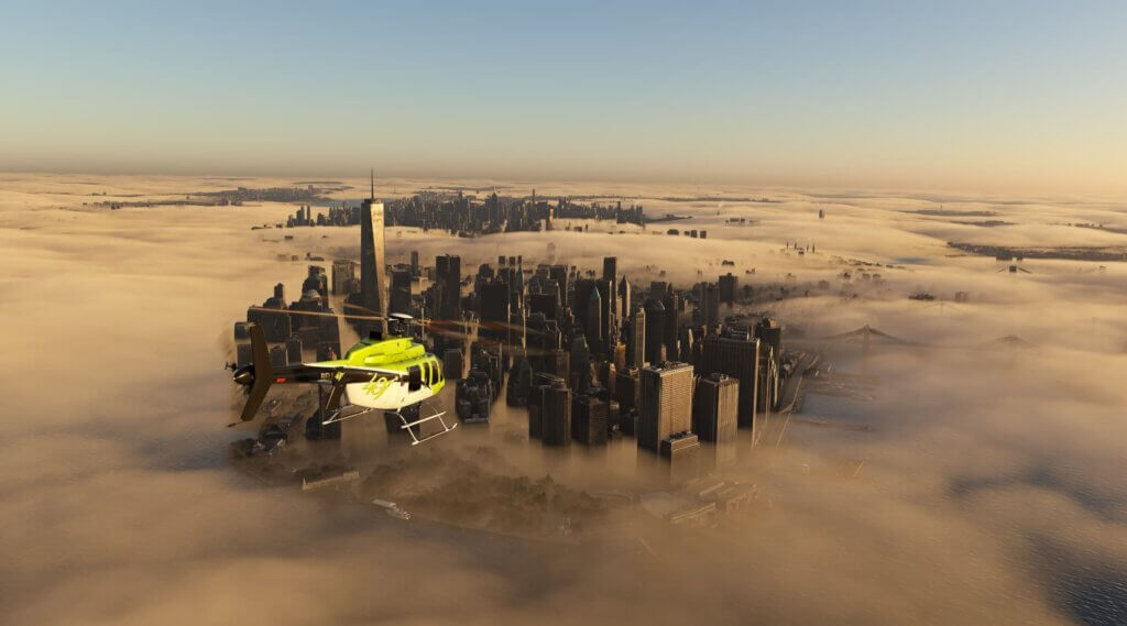 The Bell 407 helicopter flies towards a cityscape, which is being partially hidden by cloud cover