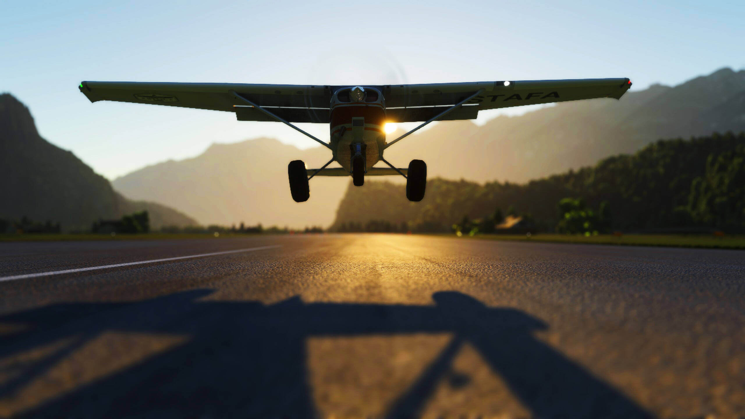 A Cessna 152 moments from touch down with flaps extended and the sun just visible through a wing strut behind.