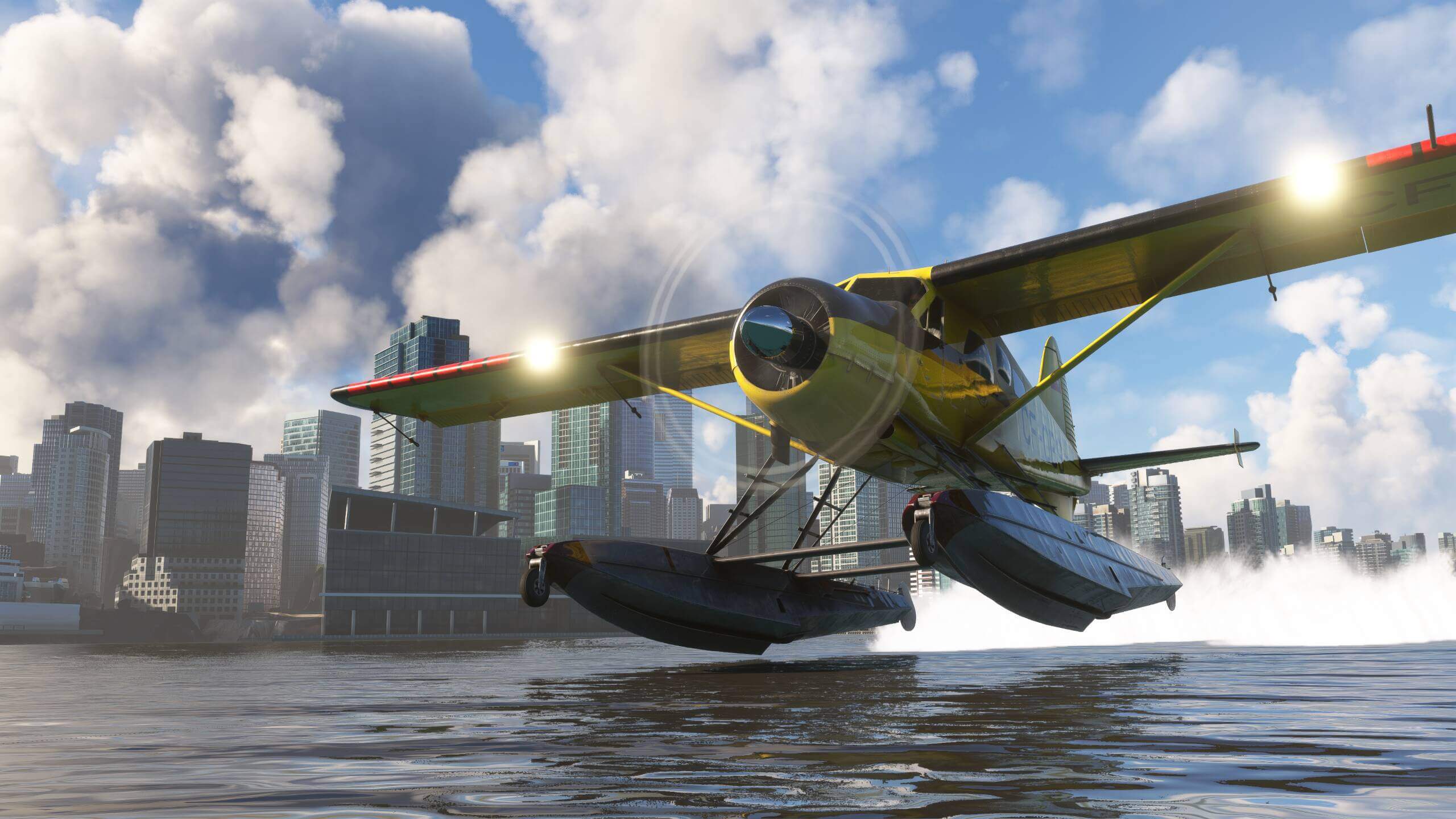 A propeller aircraft with floats sprays water behind as it takes off, with city skyscrapers behind.