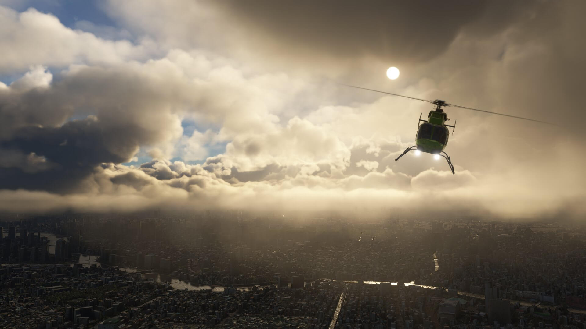 A green helicopter with landing lights turned on flies above a dense city, with the sun reflecting back off of large cloud build ups nearby.