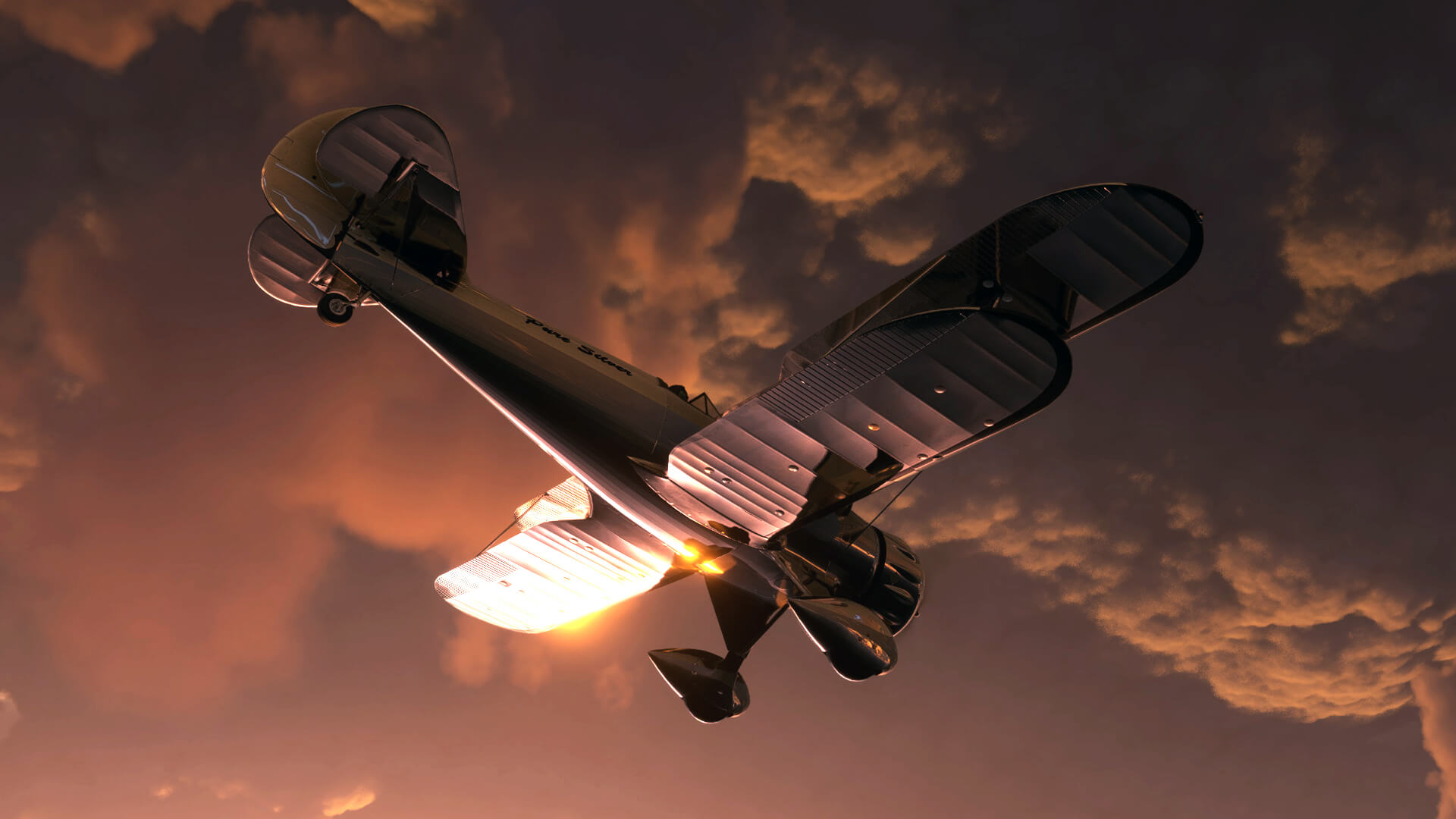 A silver bi-plane has the sun reflecting off of the lower side of its left wing and fuselage, as it flies below orange and grey overcast clouds.