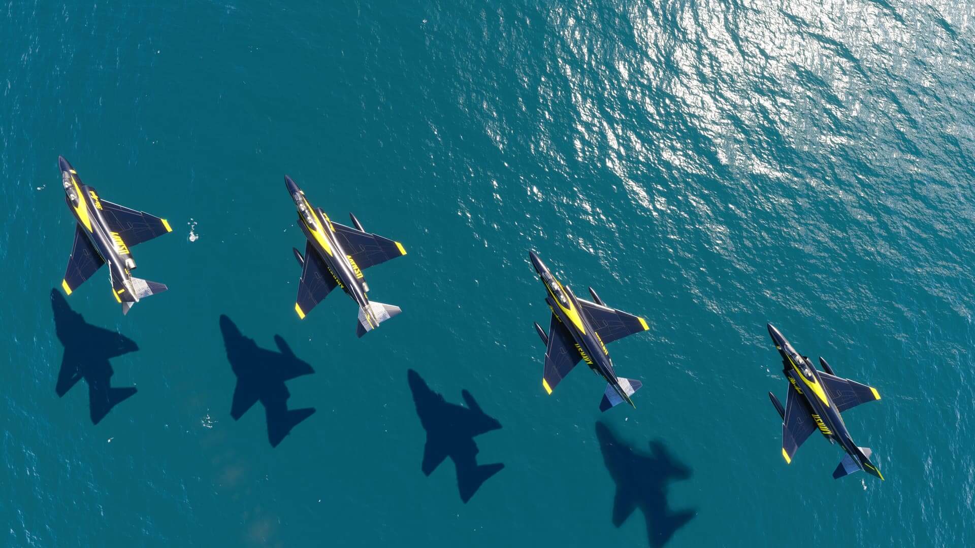 Four McDonnell Douglas F4 Phantom's in Blue Angels paint scheme fly in close formation over water with their shadows casting on the surface below.