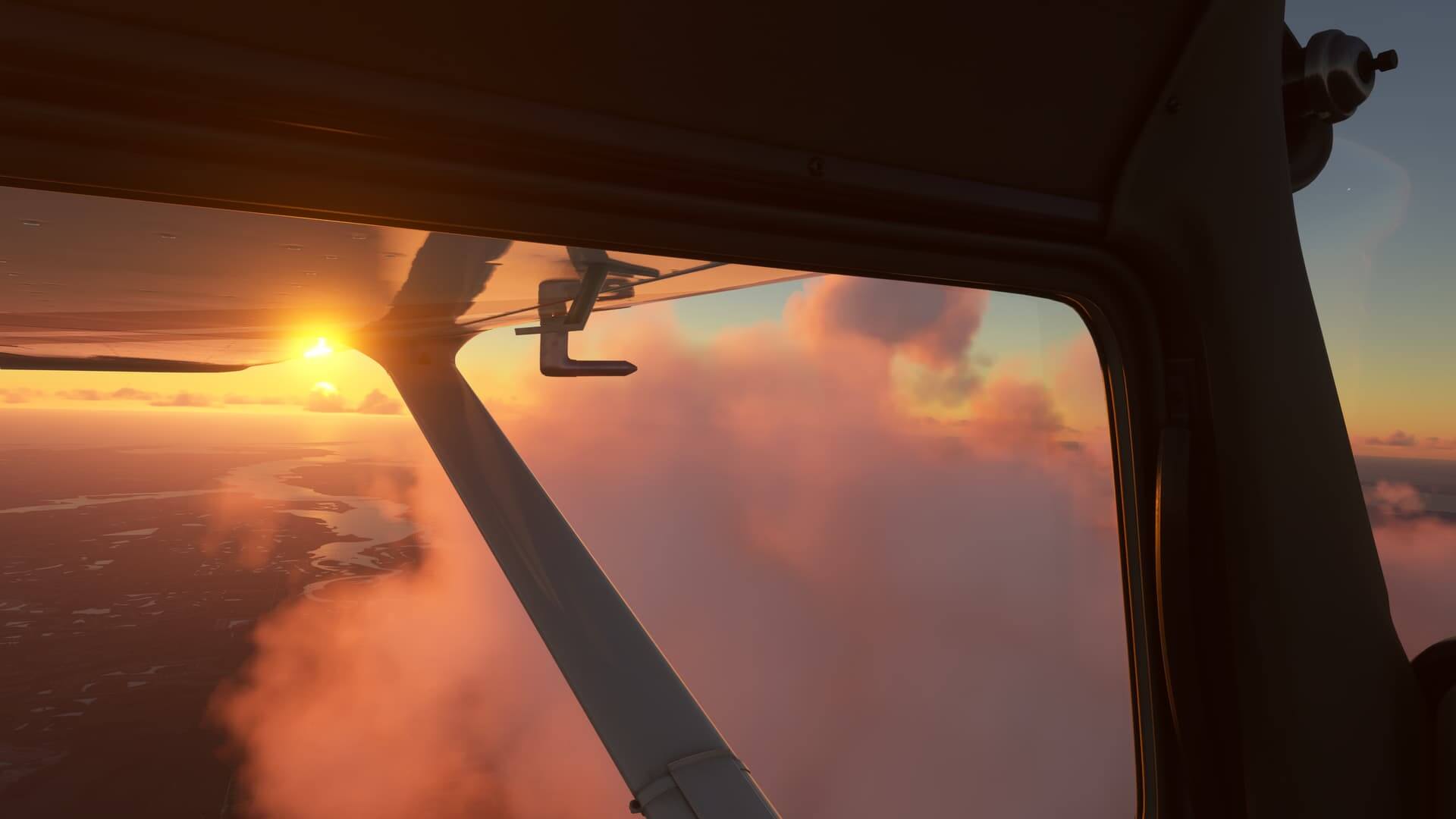 A view from the cockpit of a Cessna 172, looking out of the left window towards clouds and a sunset in the distance.