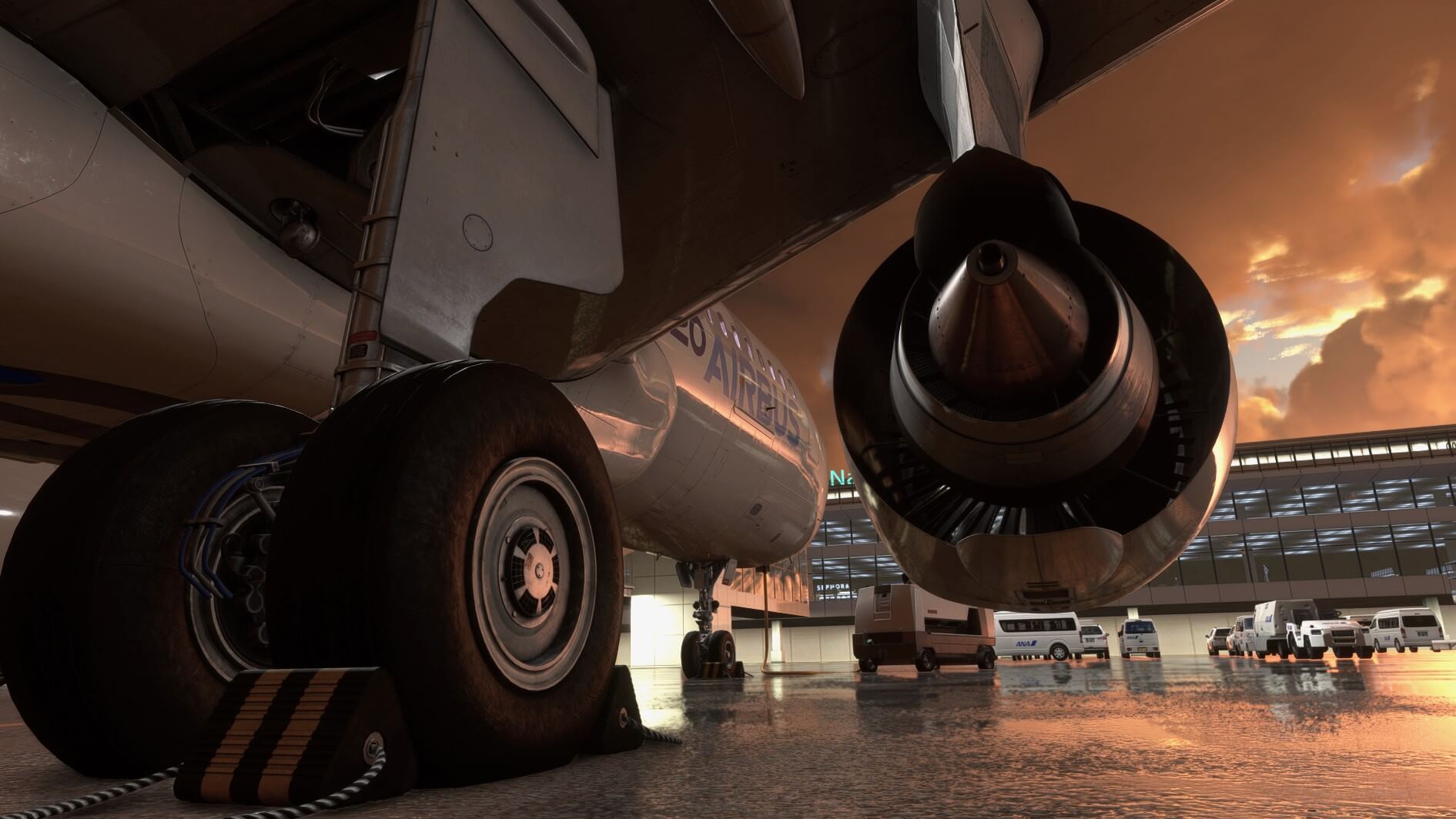 A view from next to the right landing gear of an Airbus A320 with the right engine in view as it is parked on the ramp.