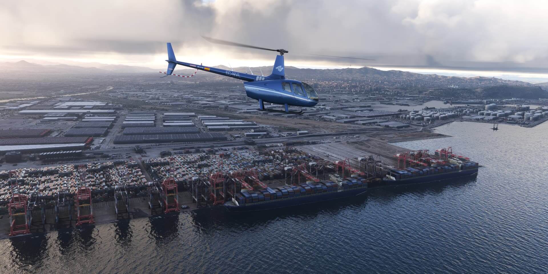 A Robinson R66 Helicopter cruises low by the port of Barcelona, Spain
