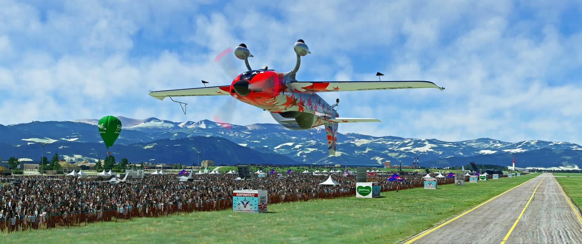 An Extra 330 flies inverted along a busy crowd line at an airshow