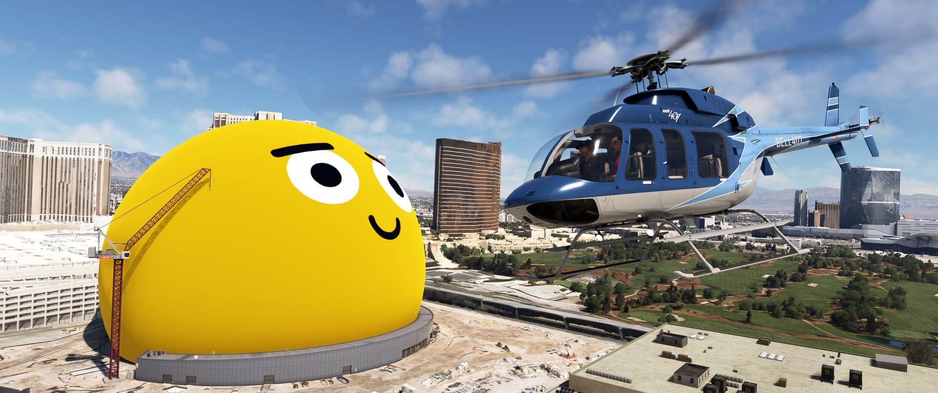 A Bell 407 flies next to the Sphere in Las Vegas, which is lit up as a yellow smiley face