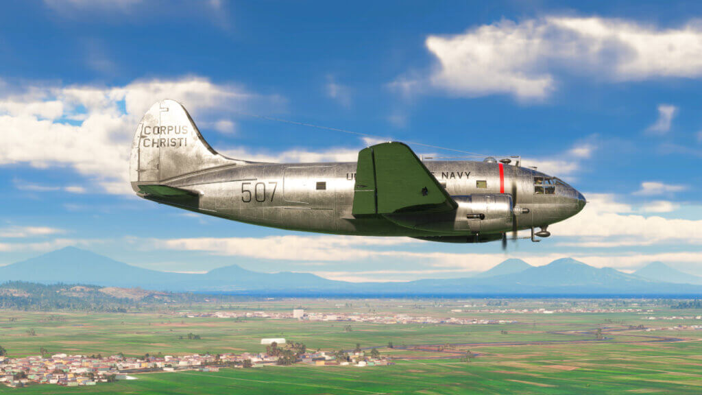 Curtiss C-46 Commando external side shot with green fields and mountains behind it