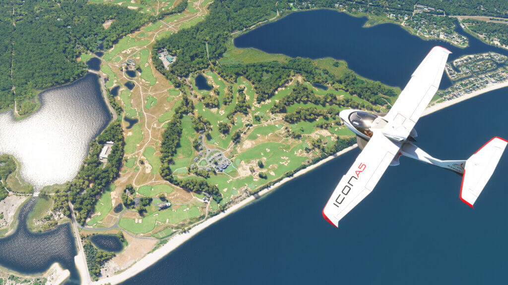 An Icon A5 flies over a large golf course