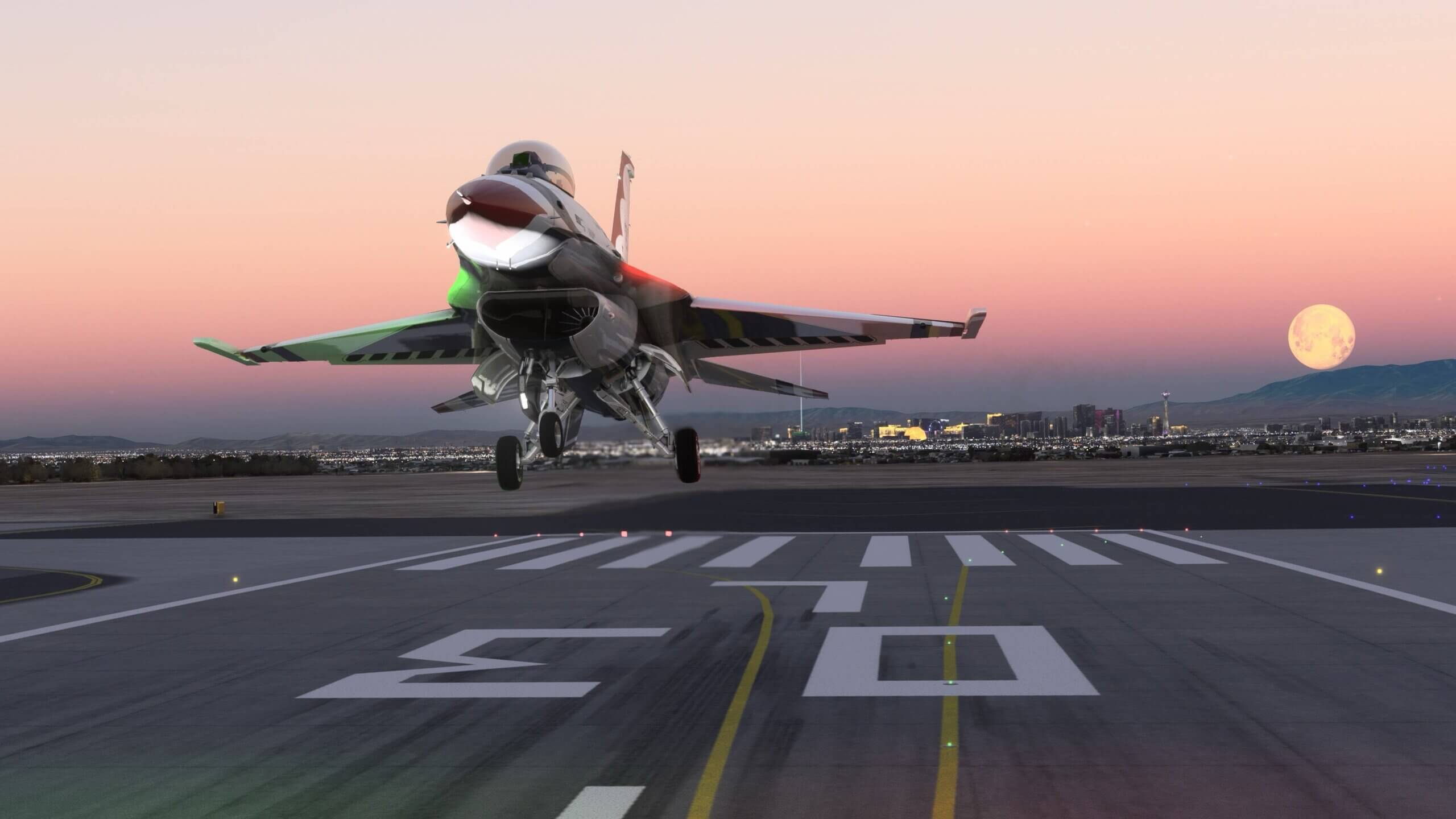 An F-16 in Thunderbirds paint lands on runway 03L at an airport whilst the moon is visible next to the city of Las Vegas behind