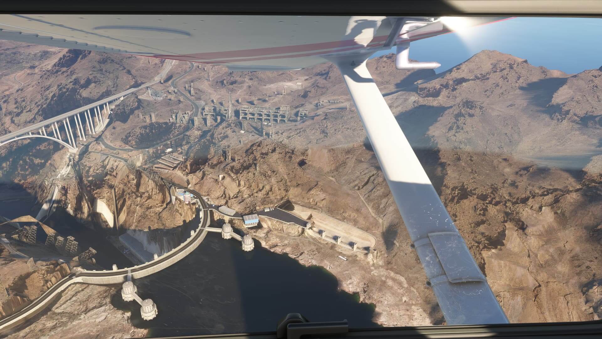 A view from inside the cockpit of a Cessna 152, looking out of the left wing at the Hoover Dam