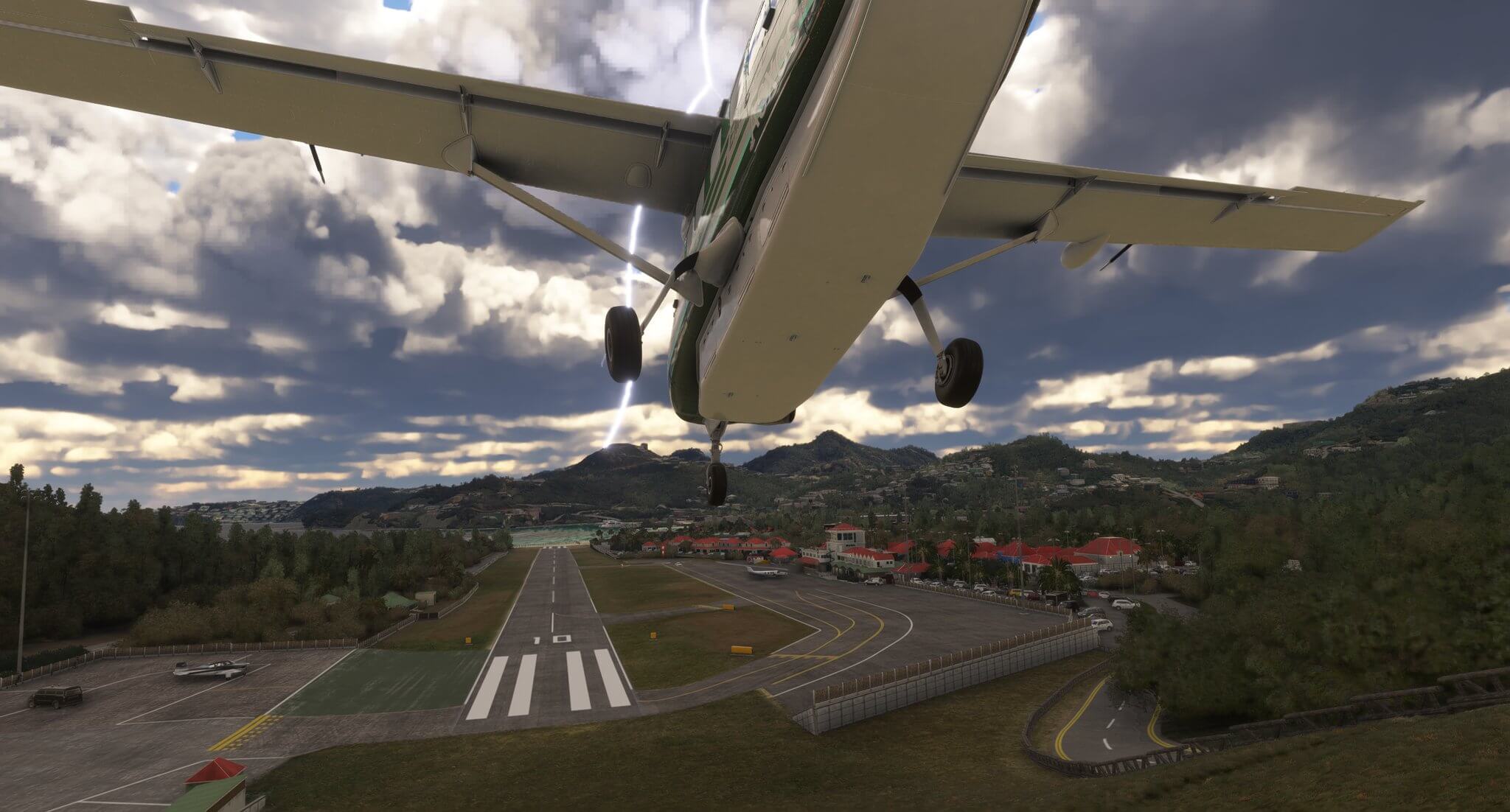 A high wing general aviation aircraft dives down on approach into St. Baarts airport, with lightening in the distance ahead