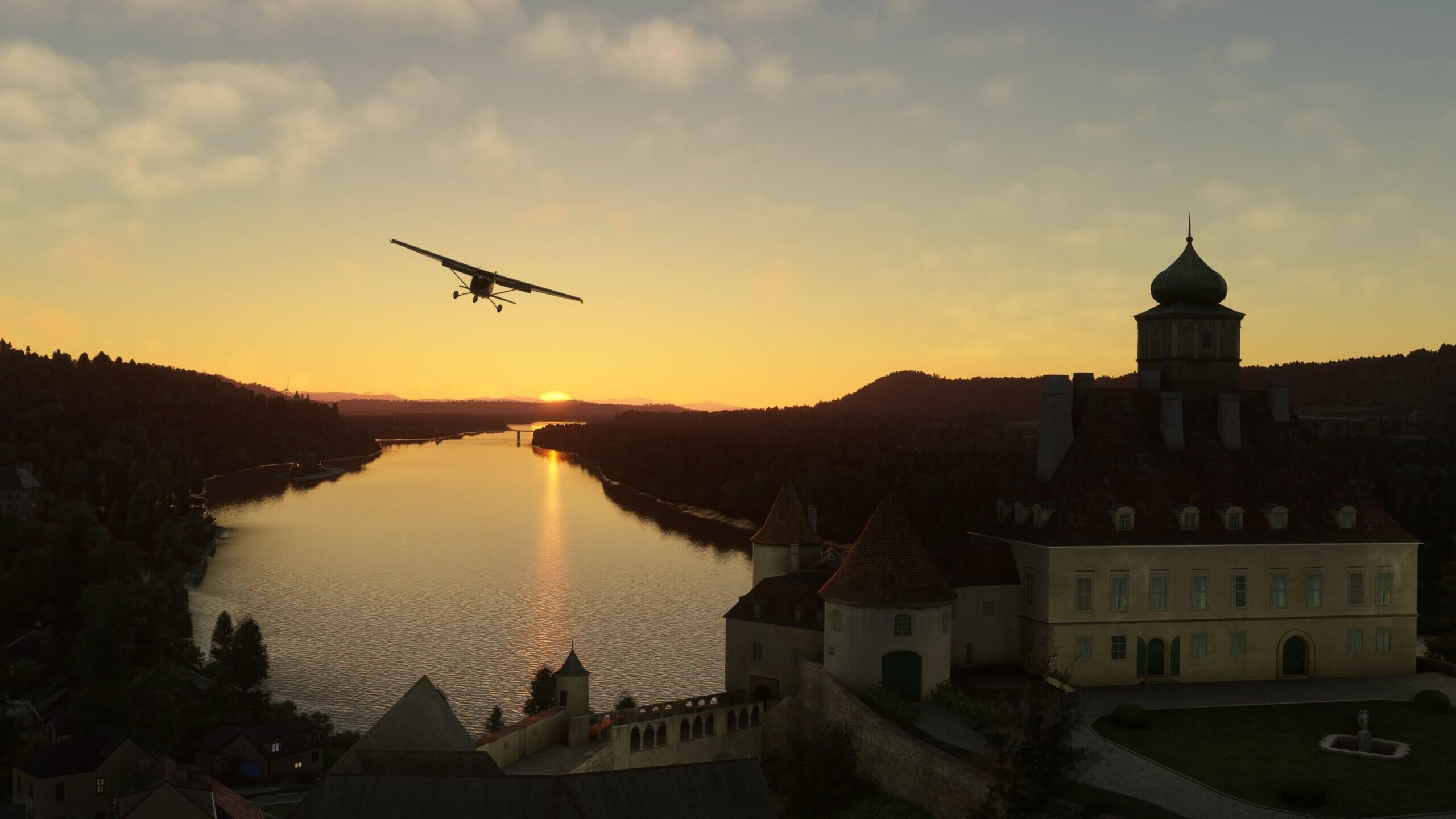 A Cessna 152 passes a castle with the sun setting behind