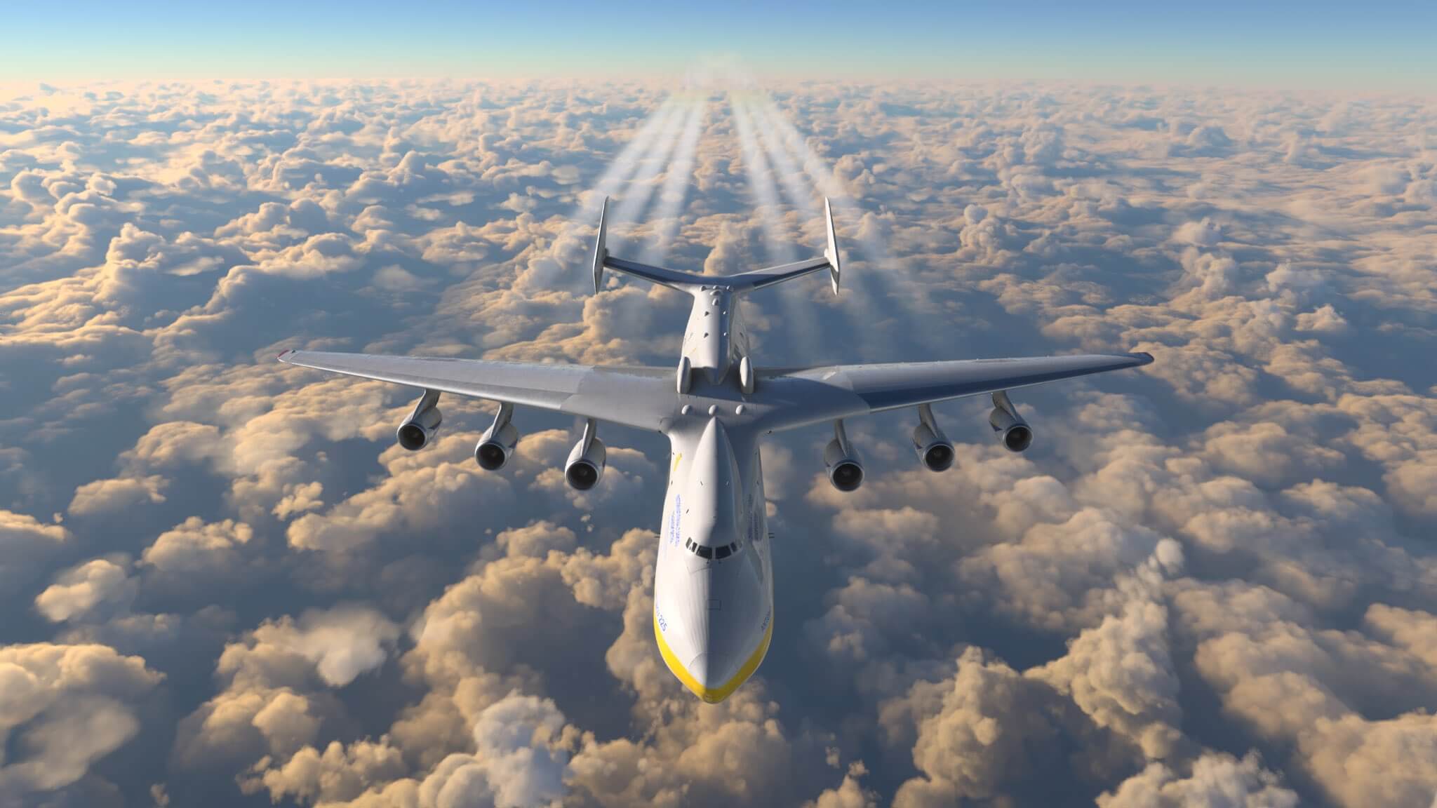 An Antonov An-225 with visible contrails flies over a cloud layer