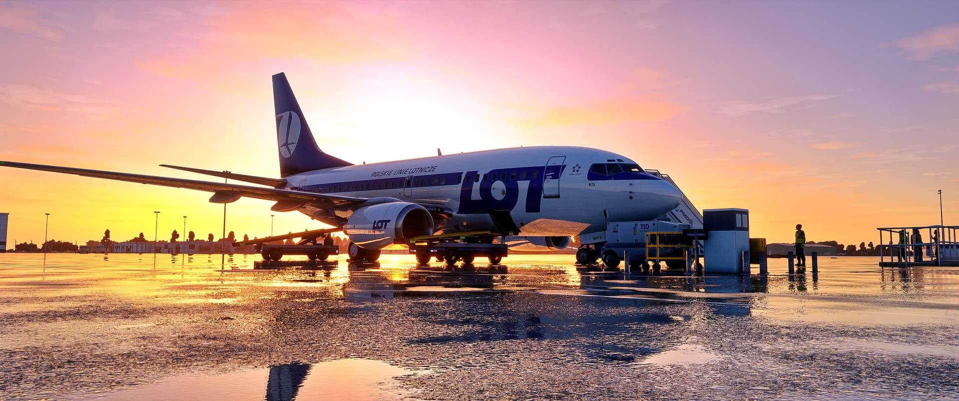 A jet airliner is parked on the ramp. The tarmac has reflective rain water.