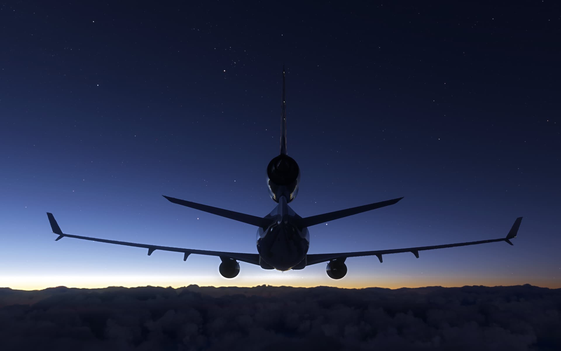 A McDonnell Douglas MD11 flies under a blue night sky.