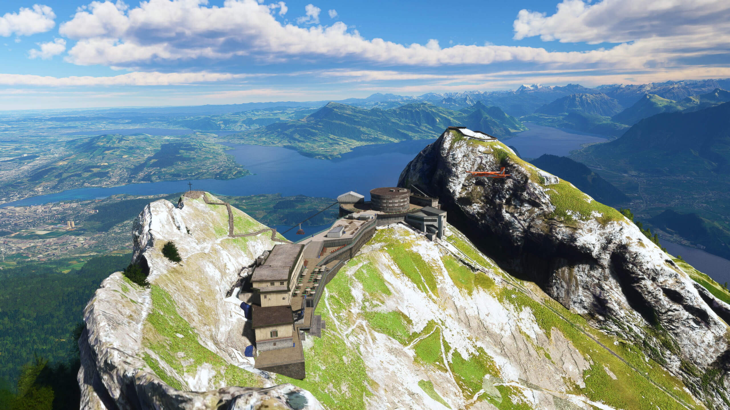 A Pilatus PC-6 Porter flies above a mountain resort