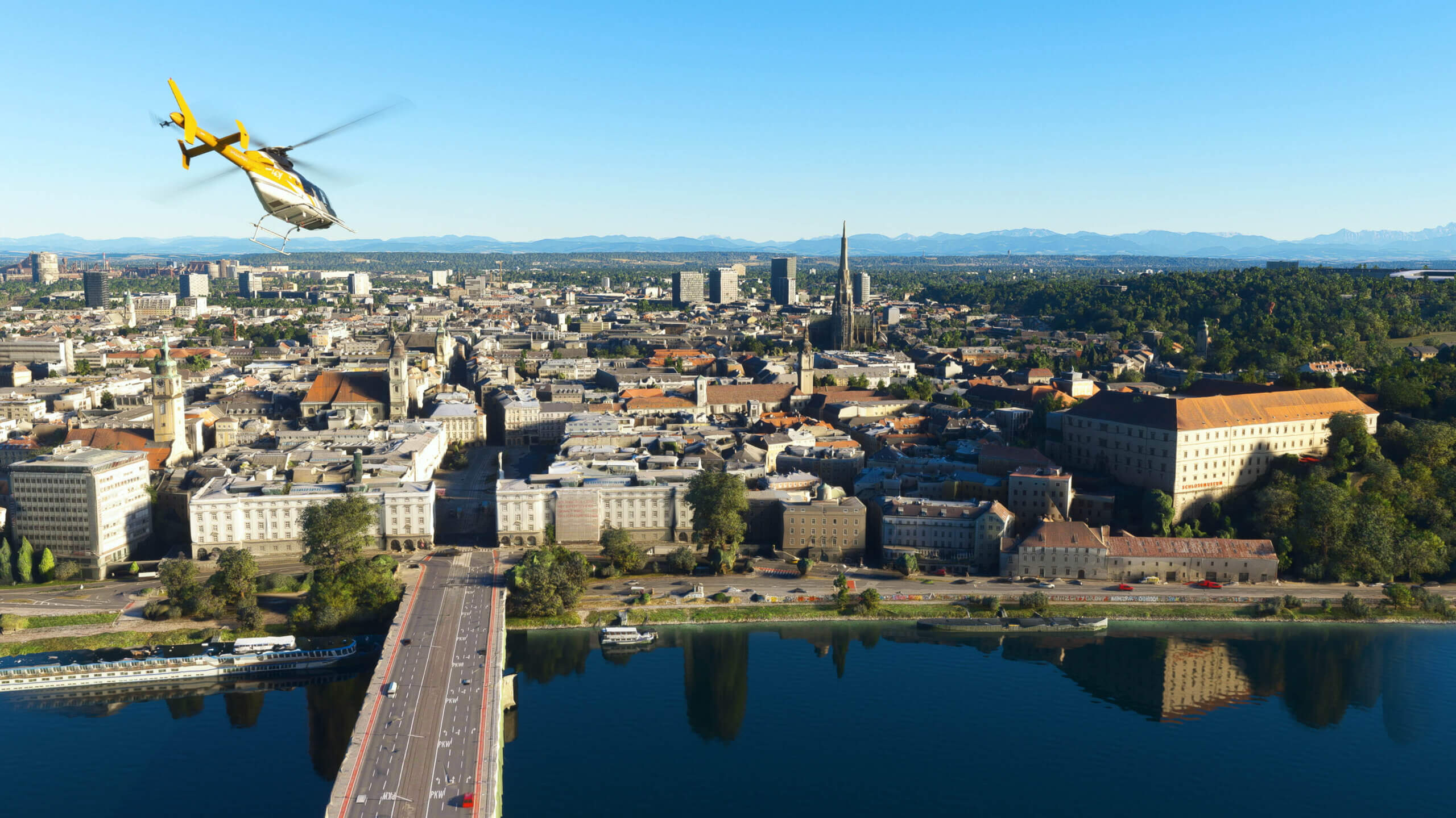 A Bell 407 helicopter flies over a city.