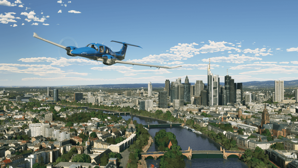 A Diamond DA52 in flight over a city. A river with several bridges is visible below.