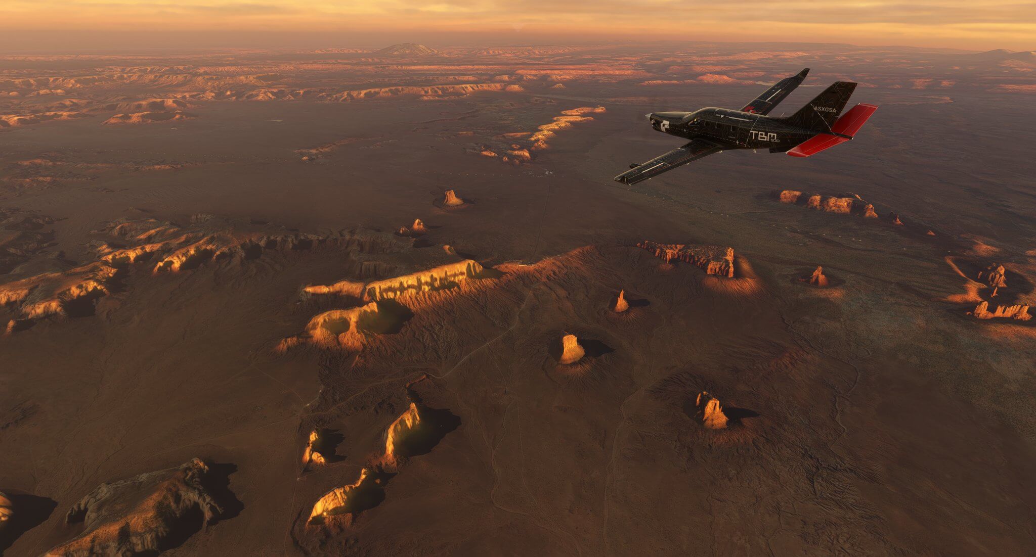 A TBM930 banks left whilst flying high above a desert