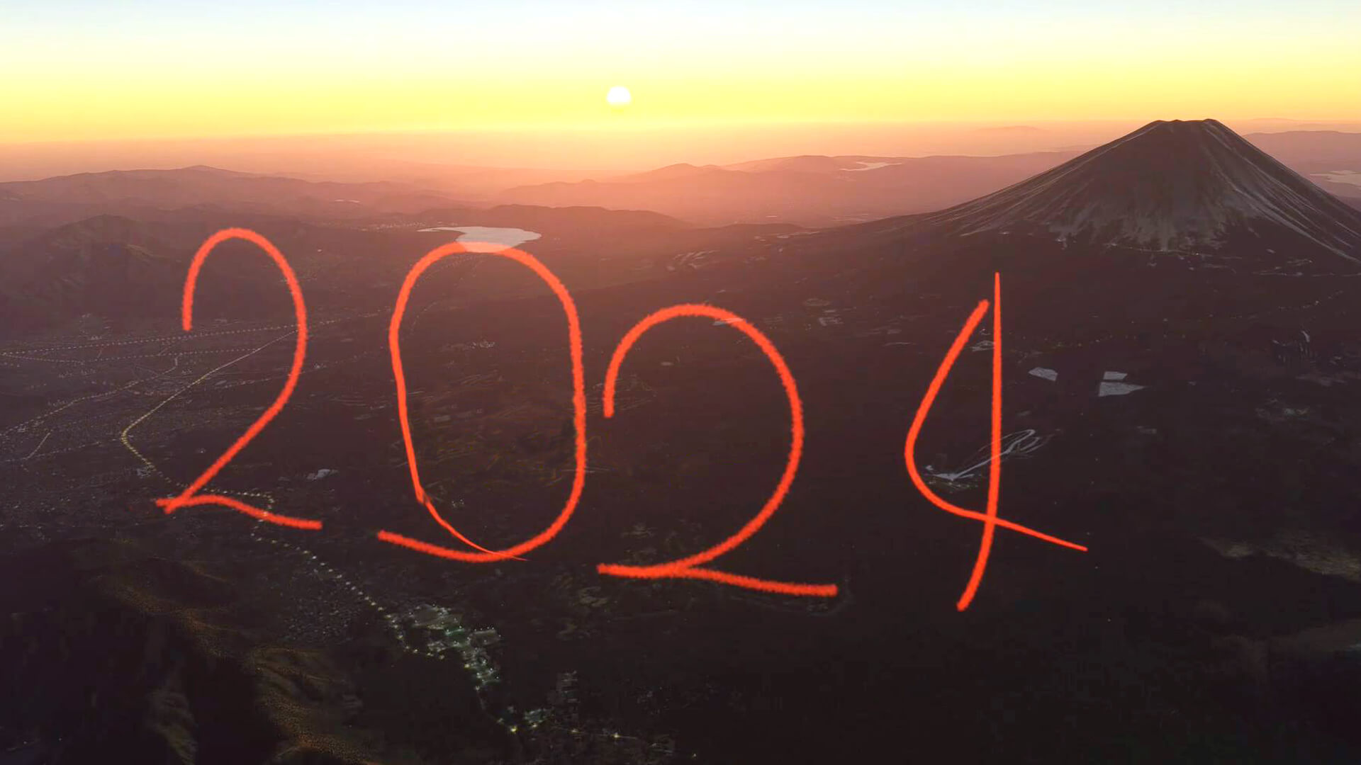 Red smoke makes up the number "2024" in the sky next to Mount Fuji, with the sun rising behind.