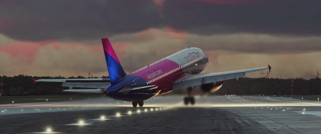 A Wizzair Airbus A320 crabs to the right whilst touching down on a runway with strong crosswinds