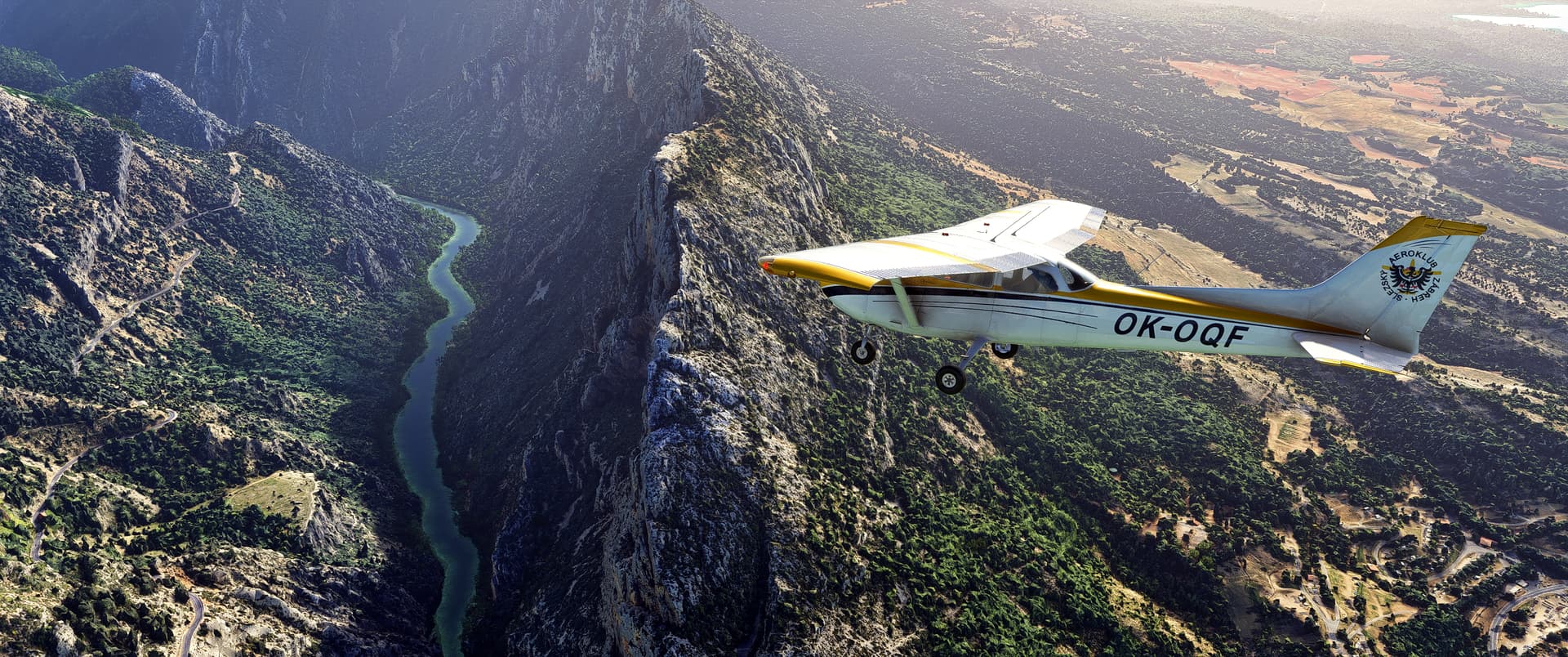 A Cessna 172 pitches nose down towards a valley with a river running through