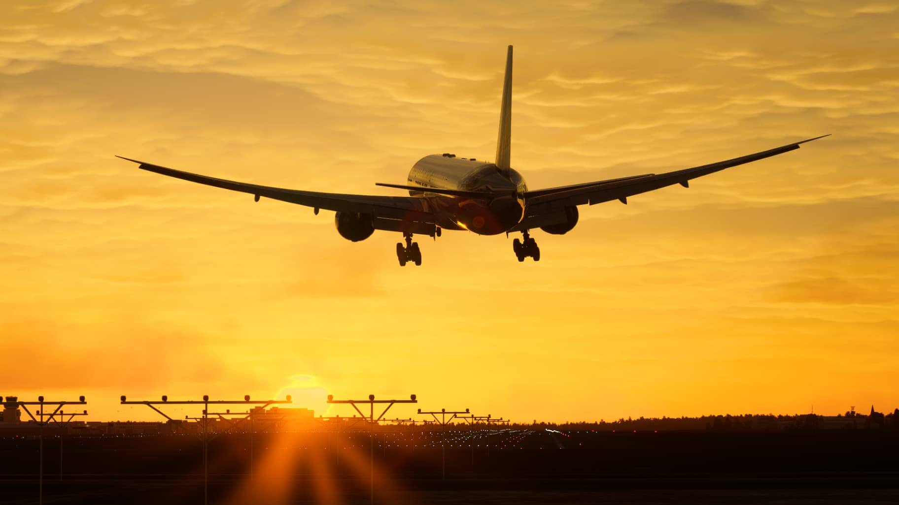 A Boeing 777 crabs into wind on landing with the sun setting in the distance ahead