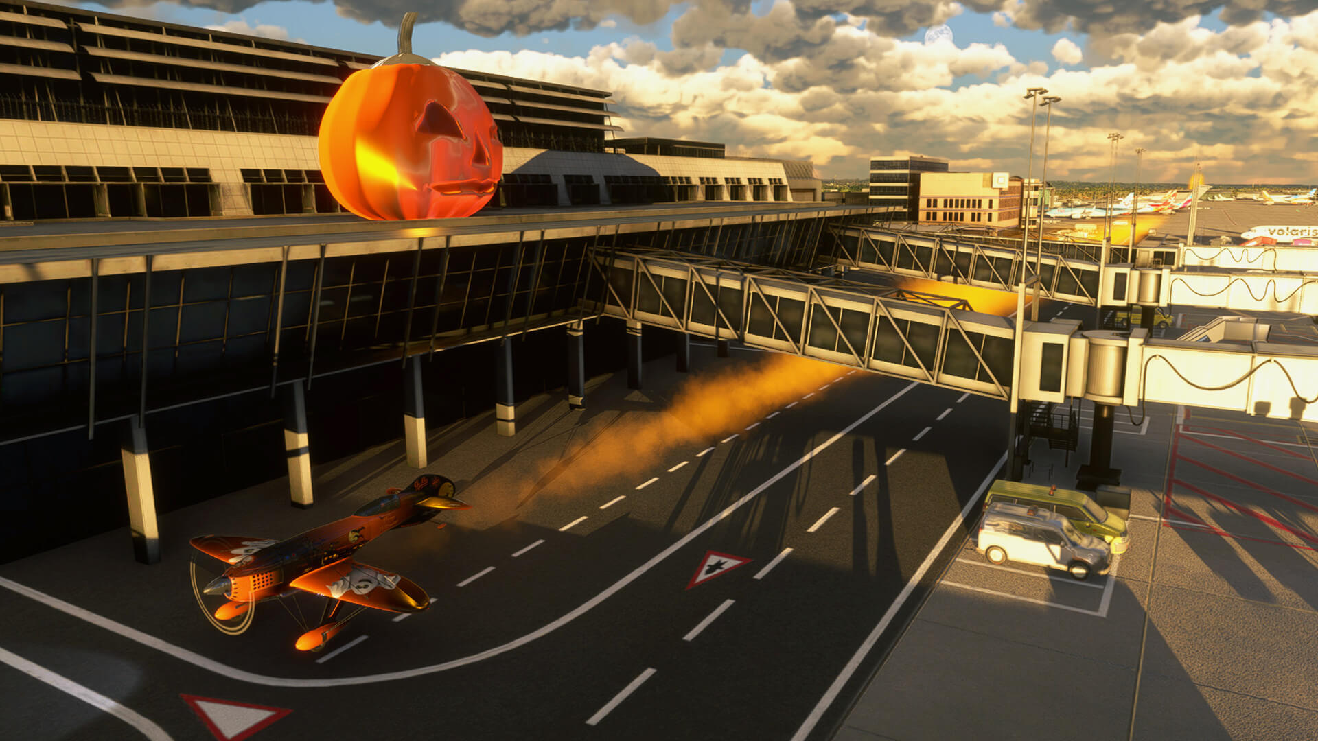 A Halloween themed aerobatic plane passes under jetways with orange smoke pluming at an international airport